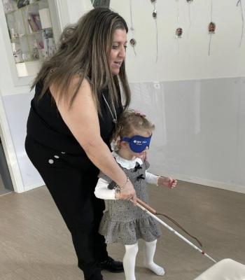Fillette avec un masque et une canne d'aveugle essayant de marcher